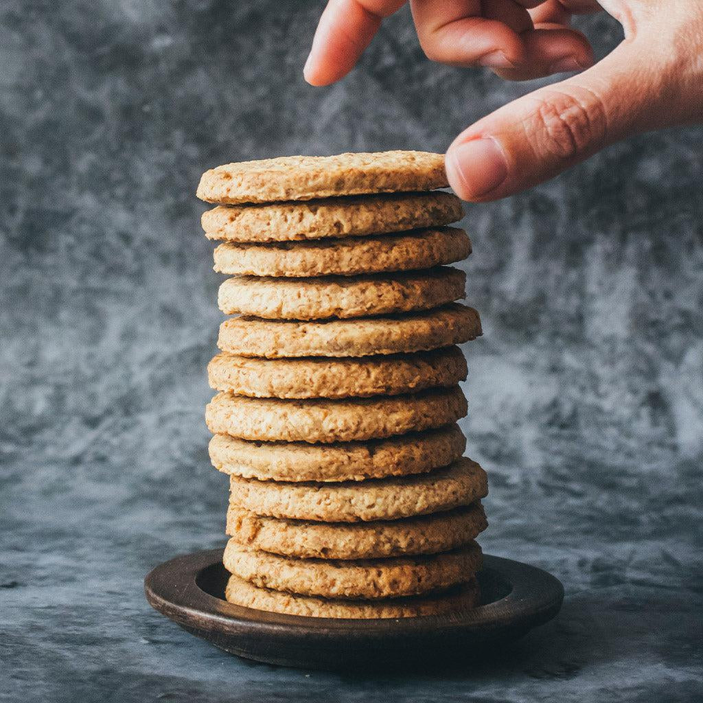 Una mano agarrando de una pila de galletas chilenas.