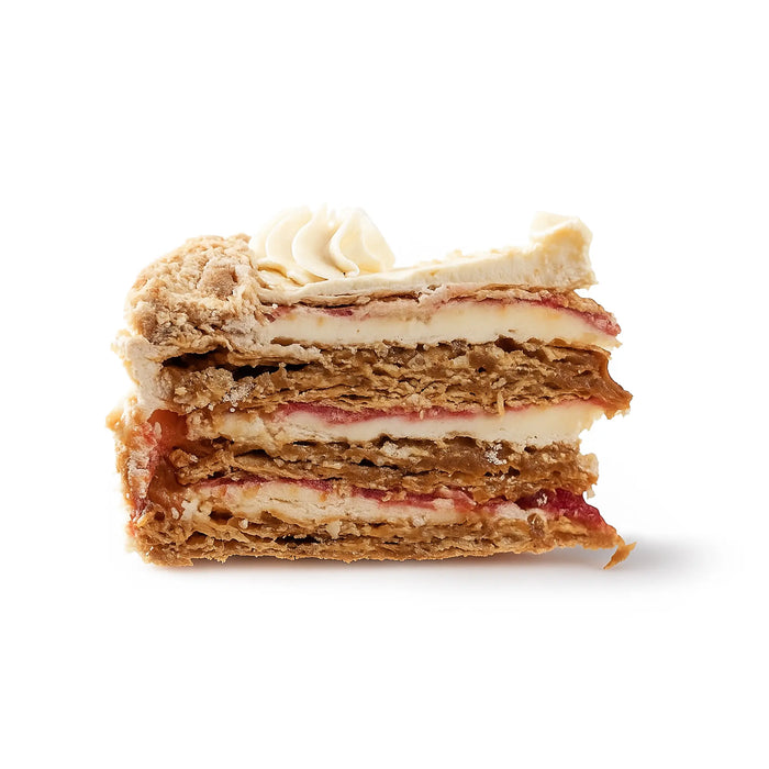 Postre en capas con merengue y relleno de fruta sobre fondo blanco