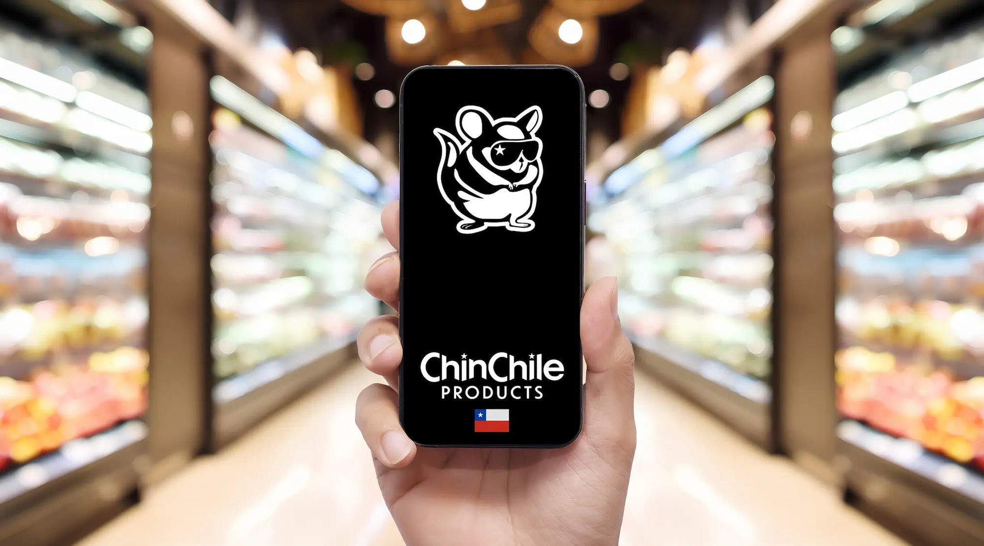 Logotipo de la mascota de ChinChile Products en un smartphone sostenido en el pasillo de un supermercado con estantes de comida borrosos.